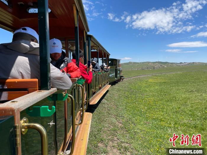 图为游客乘坐小火车赏草原。　黄花沟草原旅游区 摄